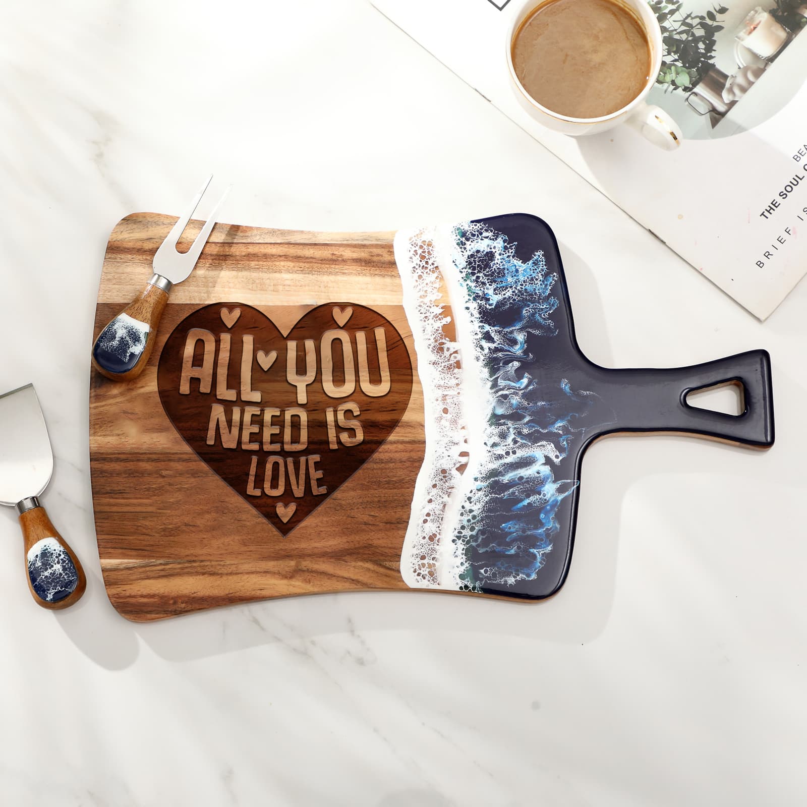All You Need is Love fan resin cutting board styled on a marble surface with coffee and cheese knife props