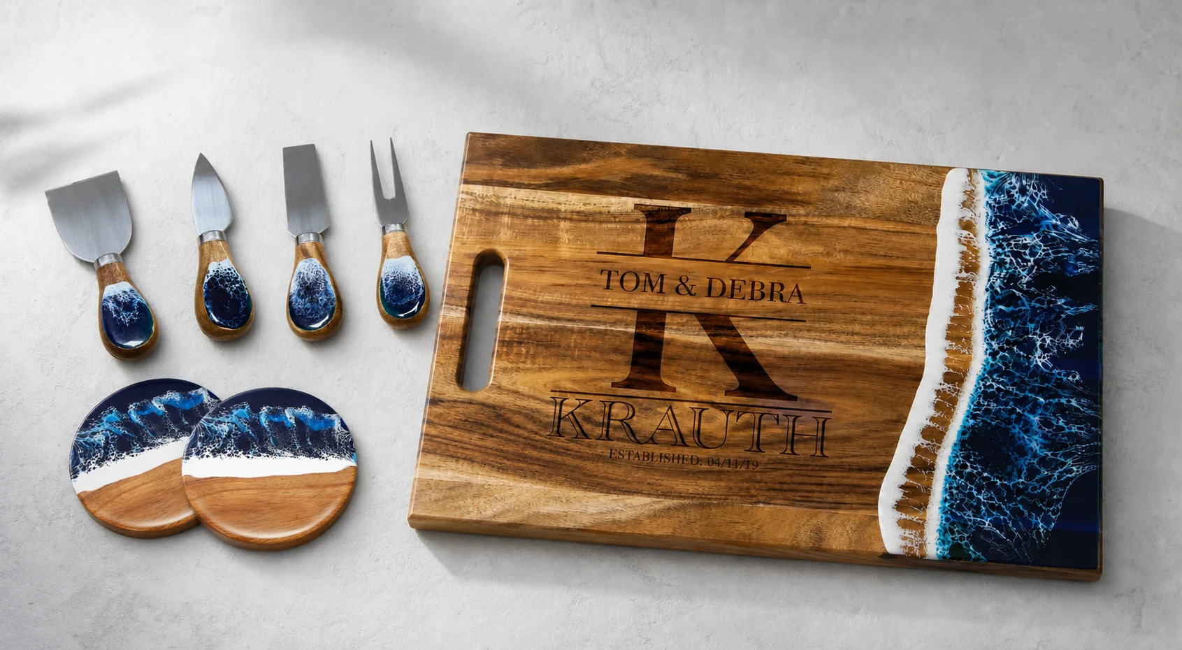 Personalized acacia wood and blue resin cutting board with four matching cheese knives and two ocean-wave coasters